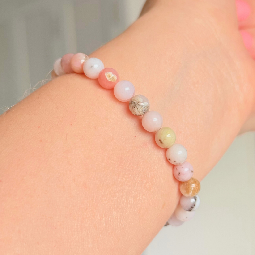Pink opal bracelet featuring 6mm genuine round pink opal beads, with one faceted gold vermeil 6mm bead as the focal point. Elasticated for comfort.