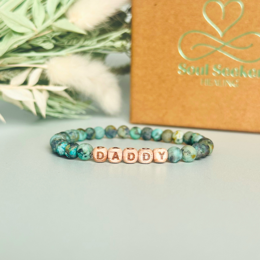 Men’s crystal bracelet with 6mm frosted African turquoise gemstone crystal beads and laser engraved wooden letter beads featuring the words best dad or can also be made with any other words or letters.