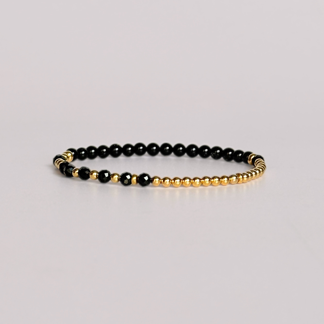 Elasticated black tourmaline crystal morse code bracelet spells out the words ‘Fuck this shit’ in a combination of 4mm round black tourmaline beads, 4mm faceted black tourmaline beads and either sterling silver or gold vermeil 3mm round beads. The words start and end at the rondelle spacer beads.