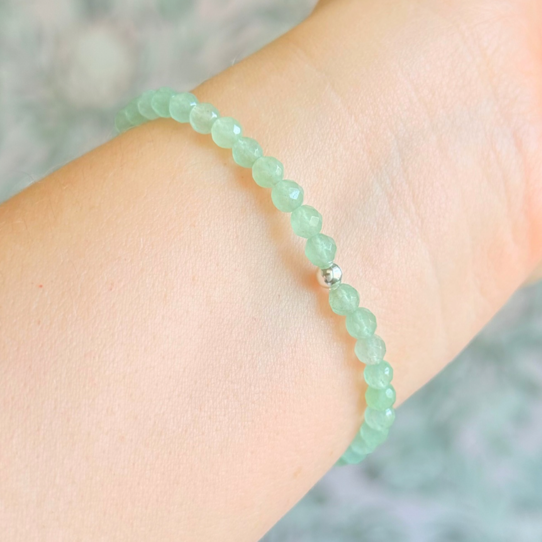 Bracelet featuring engraved wooden 888 angel number and wing beads, on the band of 4mm faceted green aventurine round crystal gemstone beads. Finished with your choice of gold vermeil, sterling silver or rose gold vermeil accent beads.