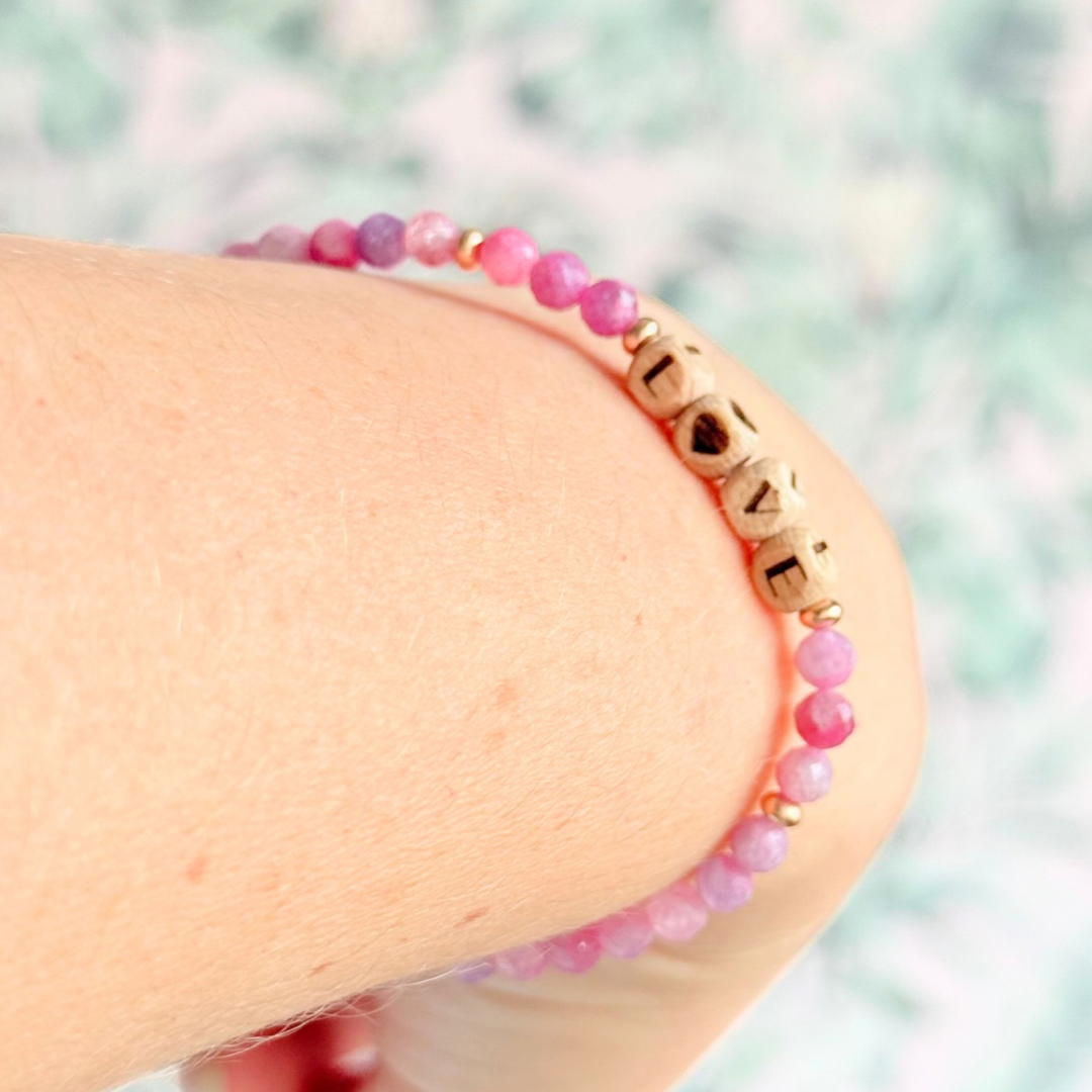 Bracelet featuring 5mm engraved wooden beads which you can personalise with your choice of words, numbers and symbols. The main the band of the bracelet is made with 4mm faceted pink tourmaline round crystal gemstone beads. Finished with your choice of gold vermeil, sterling silver or rose gold vermeil accent beads.