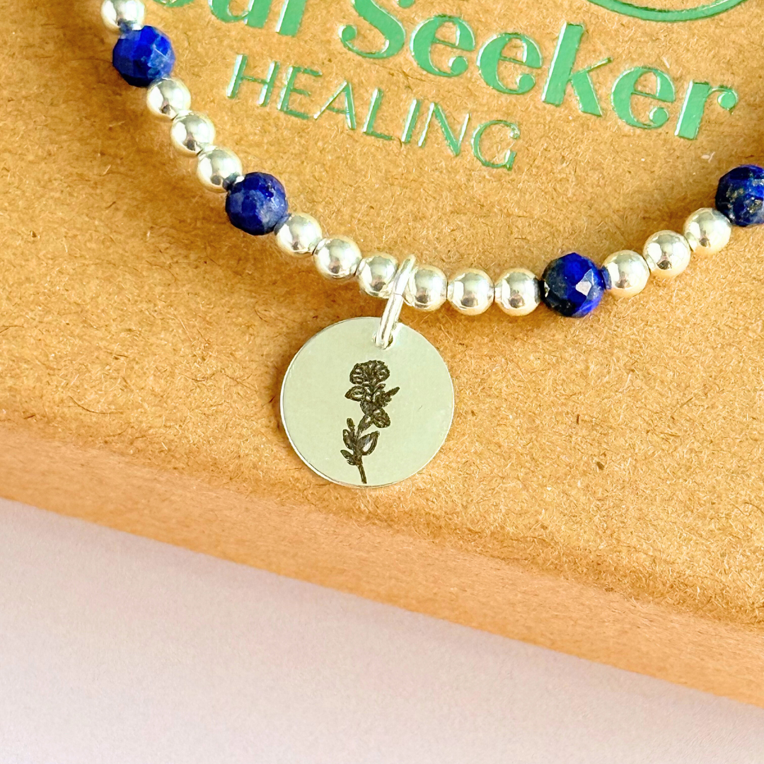 Sterling silver elasticated bracelet featuring 4mm faceted round lapis lazuli beads, separated by 3mm sterling silver round ball beads. Featuring an 11mm sterling silver round disc charm engraved with the September birth flower Morning Glory. One side of the charm can be personalised if required.