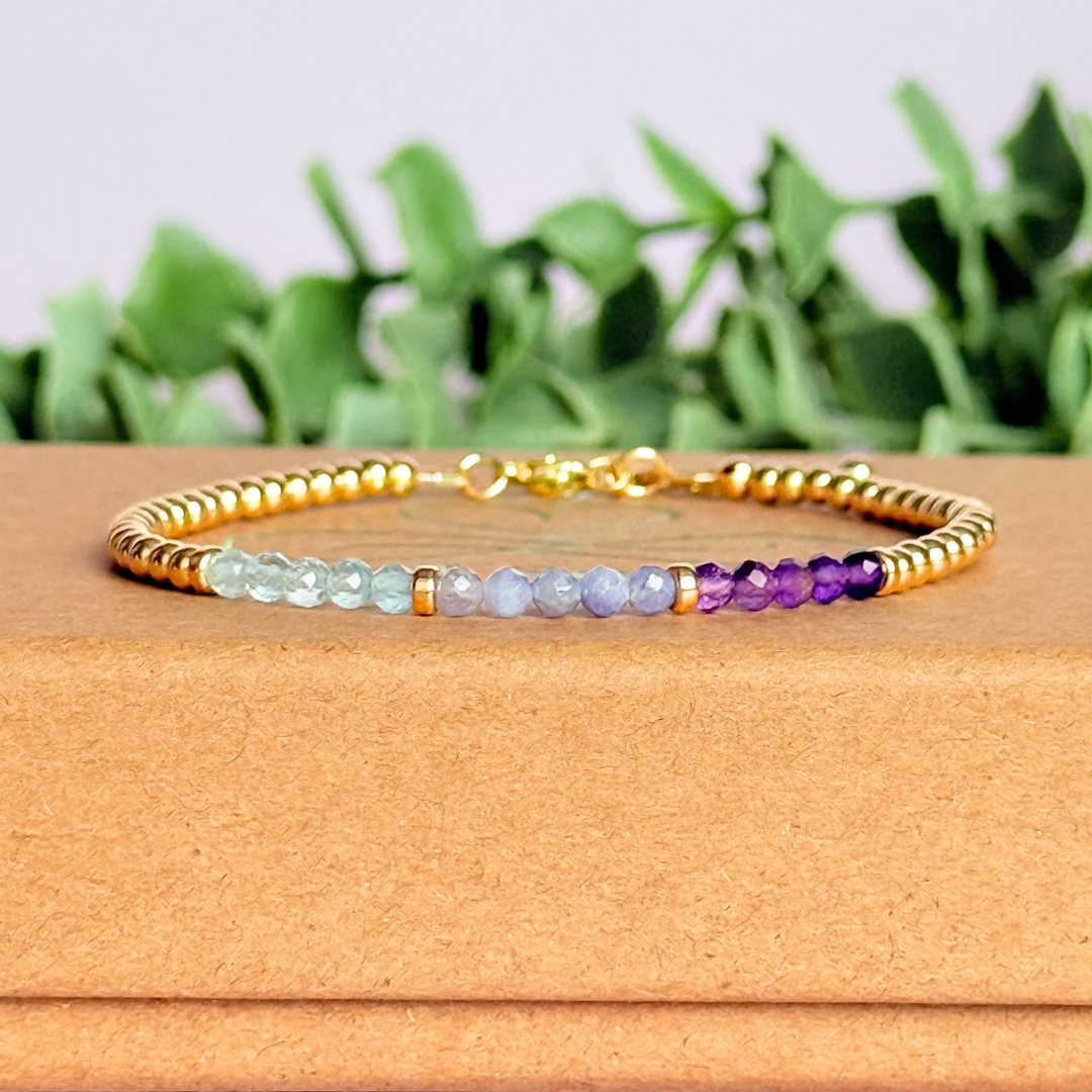 Dainty minimalist yellow gold filled crystal bracelet featuring 3mm faceted amethyst, aquamarine and tanzanite beads in a colour block Ombre style. Fastens with a gold filled lobster clasp with an extender chain.