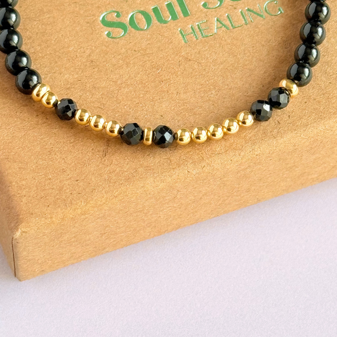 Black tourmaline crystal morse code bracelet that spells out the words ‘Let them’ in a combination of 4mm round black tourmaline beads, 4mm faceted black tourmaline beads and either sterling silver or gold vermeil 3mm round beads. The words start and end at the rondelle spacer beads.