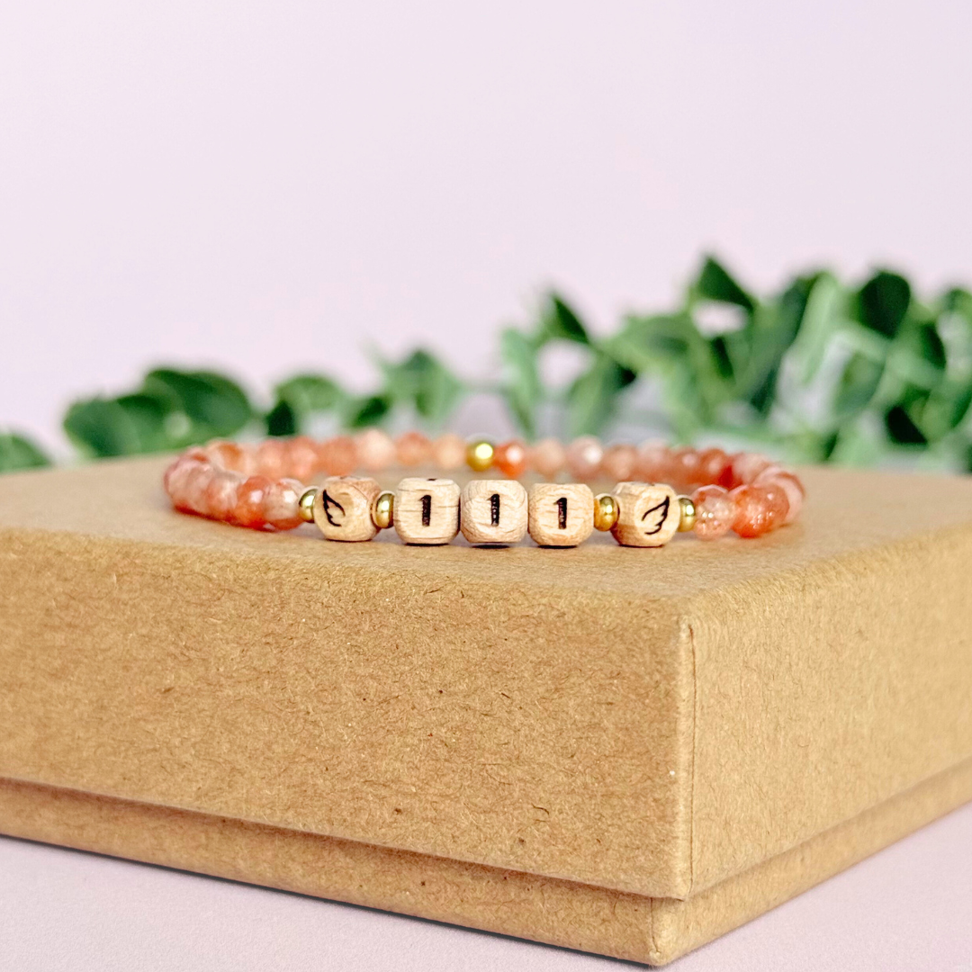 Bracelet featuring engraved wooden 111 angel number and wing beads, on the band of 4mm faceted sunstone round crystal gemstone beads. Finished with your choice of gold vermeil, sterling silver or rose gold vermeil accent beads.
