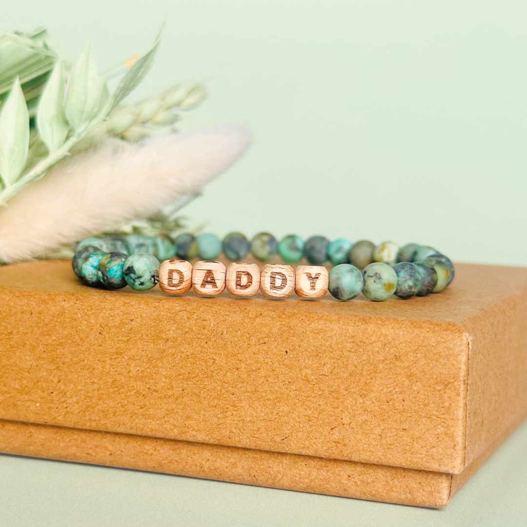 Men’s crystal bracelet with 6mm frosted African turquoise gemstone crystal beads and laser engraved wooden letter beads featuring the words best dad or can also be made with any other words or letters.