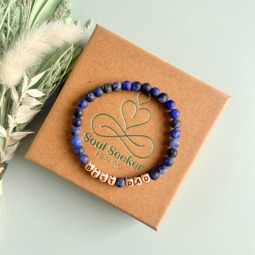 Men’s crystal bracelet with 6mm frosted sodalite gemstone crystal beads and laser engraved wooden letter beads featuring the words best dad or can also be made with any other words or letters.