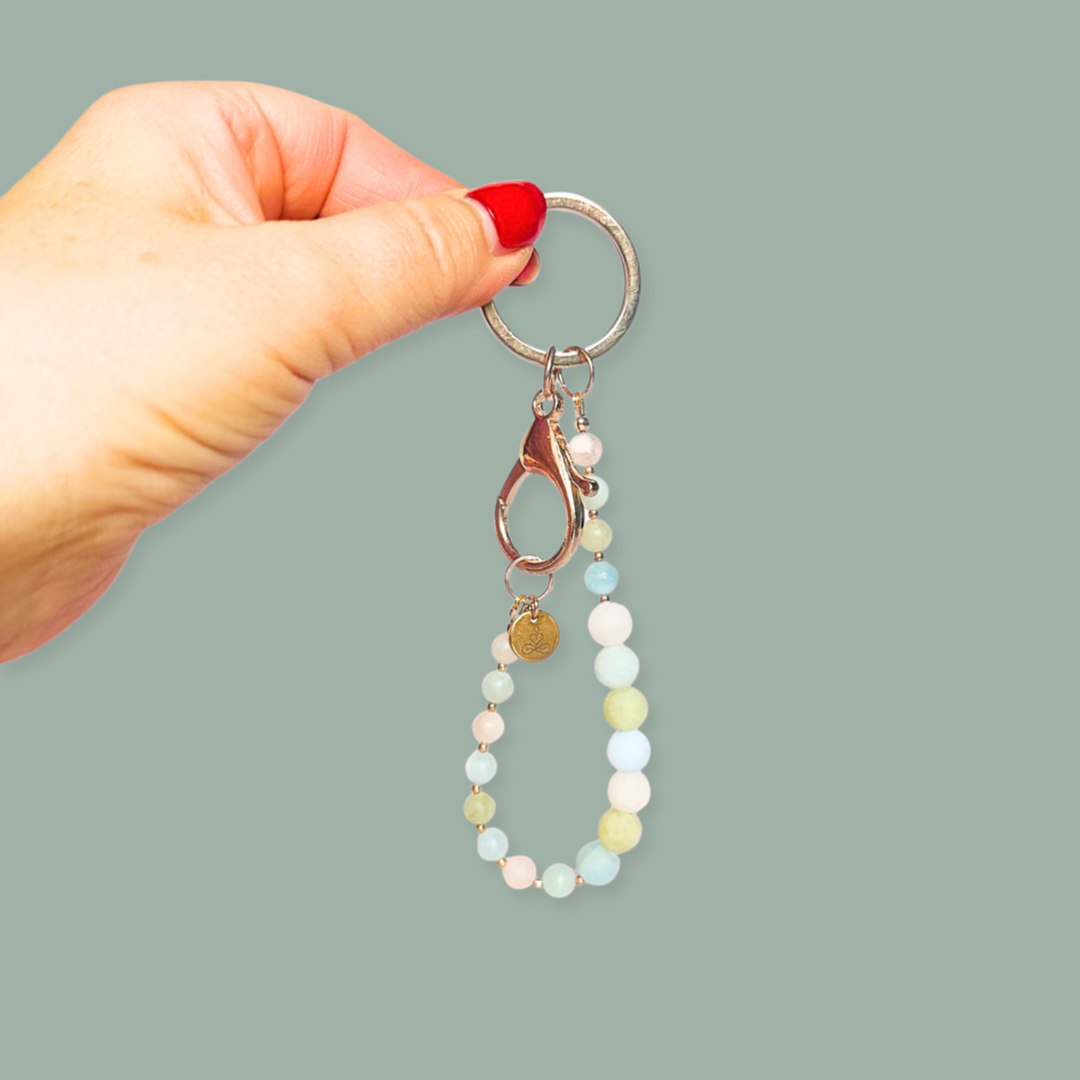 Frosted morganite breath work beads on a rose gold keychain/bag charm. For the 4-7-8 counted breathing method.