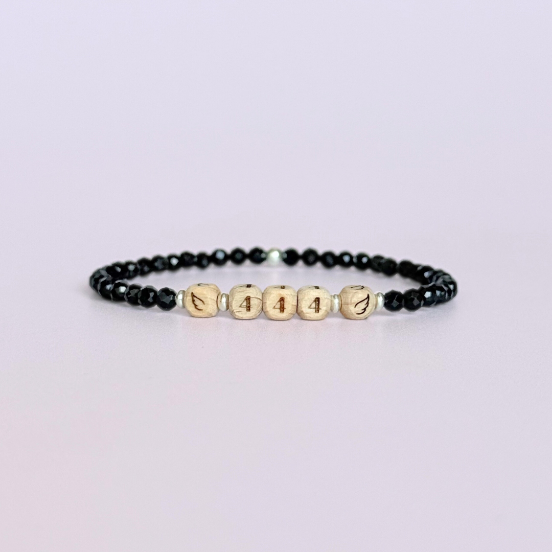 Bracelet featuring engraved wooden 444 angel number and wing beads, on the band of 4mm faceted black tourmaline round crystal gemstone beads. Finished with your choice of gold vermeil, sterling silver or rose gold vermeil accent beads.