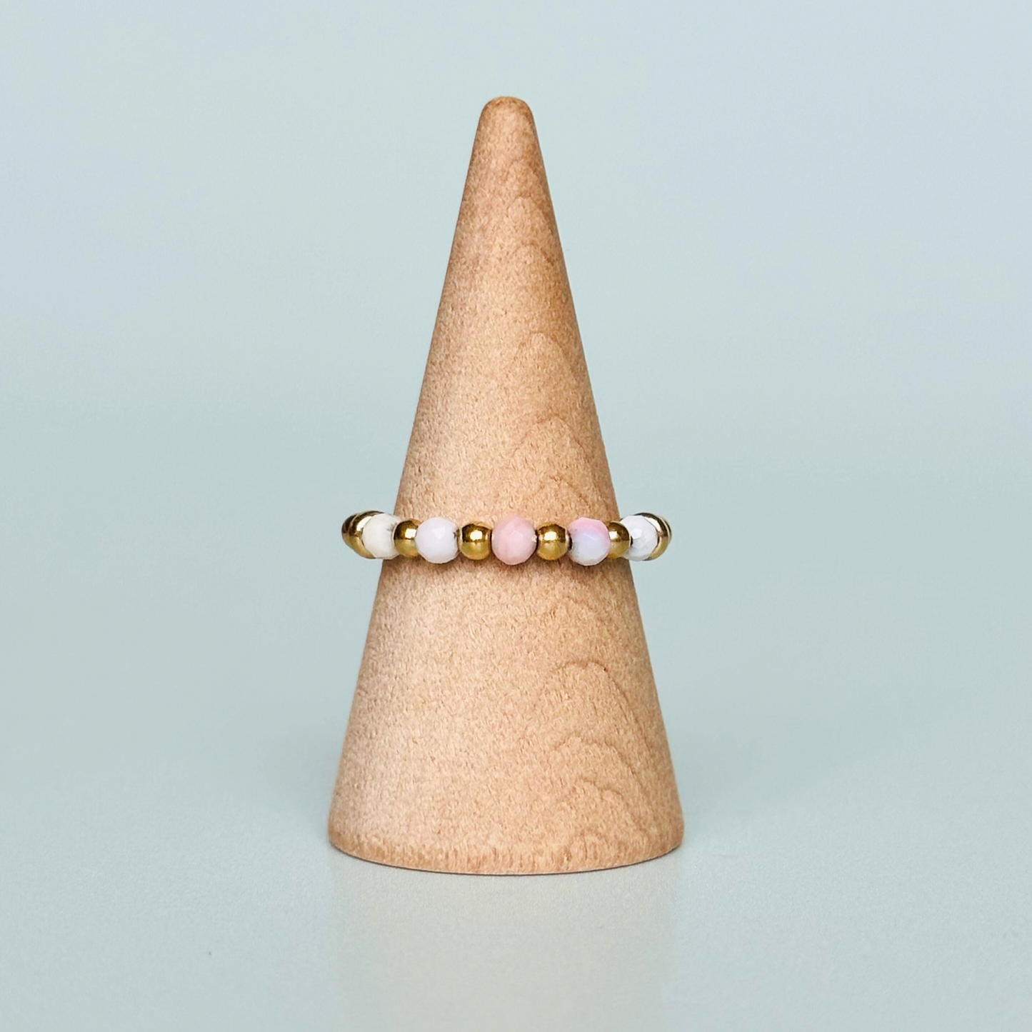 Birthstone ring featuring 5 3mm. Faceted Peruvian pink opal beads on an elasticated band of 3mm gold vermeil round beads, pink opal is an October birth stone so this makes a perfect October birthday gift.