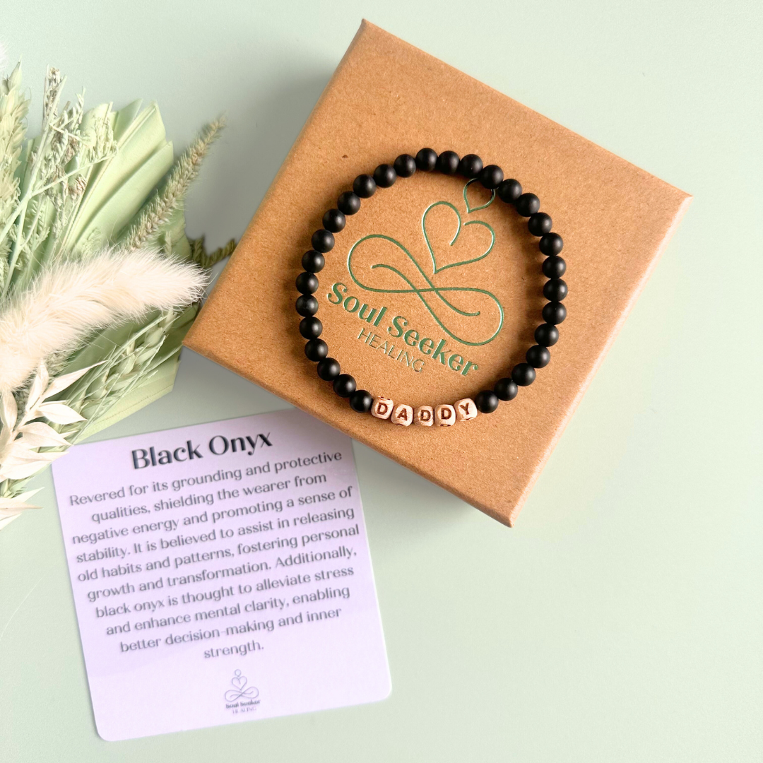Men’s crystal bracelet with 6mm frosted black onyx gemstone crystal beads and laser engraved wooden letter beads featuring the word daddy or can also be made with any other words or letters.
