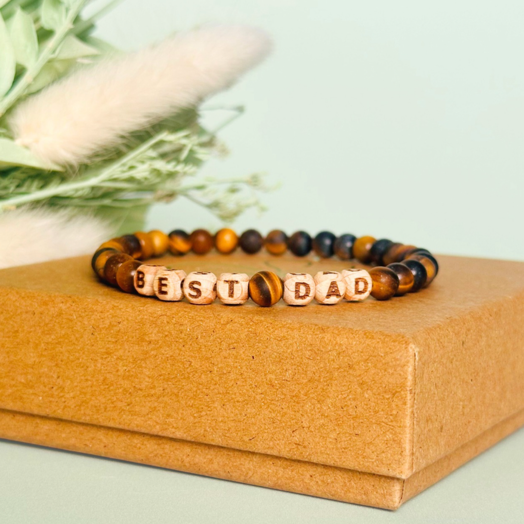 Men’s crystal bracelet with 6mm frosted tigers eye gemstone crystal beads and laser engraved wooden letter beads featuring the words best dad or can also be made with any other words or letters.