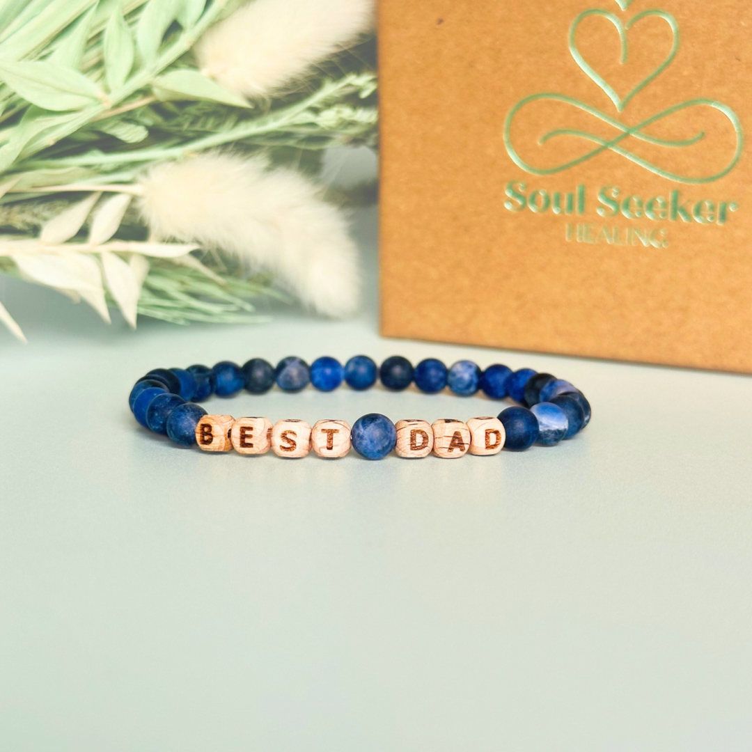 Men’s crystal bracelet with 6mm frosted sodalite gemstone crystal beads and laser engraved wooden letter beads featuring the words best dad or can also be made with any other words or letters.