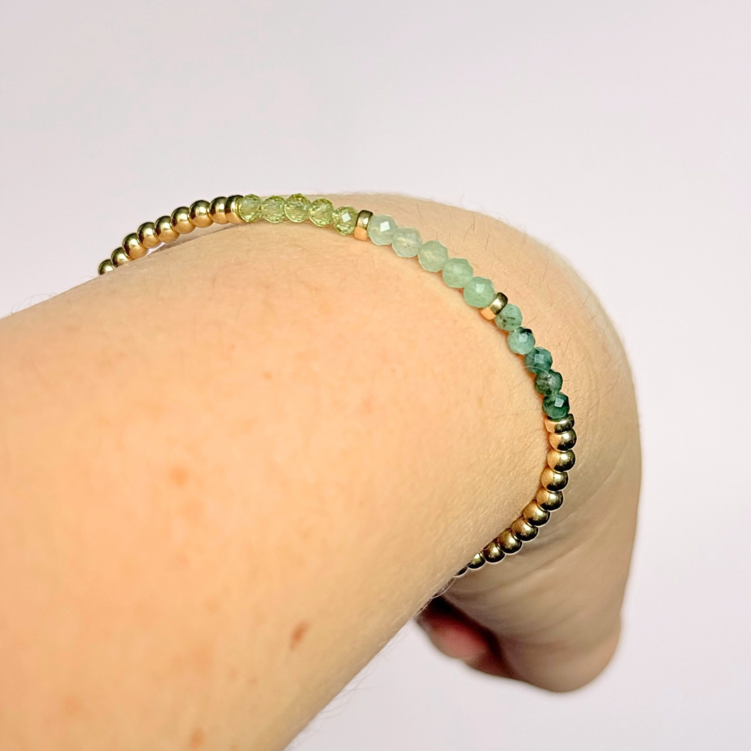 Dainty minimalist yellow gold filled crystal bracelet featuring 3mm faceted emerald, peridot and green aventurine beads in a colour block Ombre style. Fastens with a gold filled lobster clasp with an extender chain.