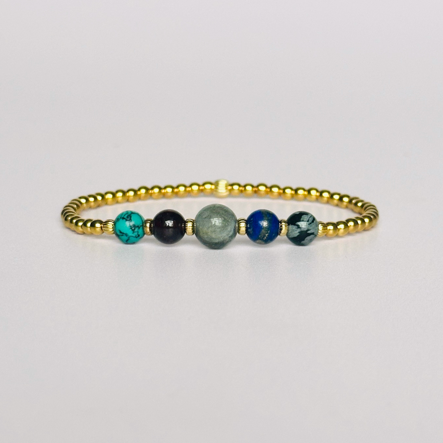 This gold vermeil Sagittarius bracelet is made with a selection of five healing crystals all believed to resonate with the Sagittarius zodiac sign. The central bead is 8mm, the other four are 6mm. On an elasticated band of 3mm gold vermeil beads with corrugated accent beads. Featuring garnet, labradorite, lapis lazuli, snowflake obsidian and turquoise.