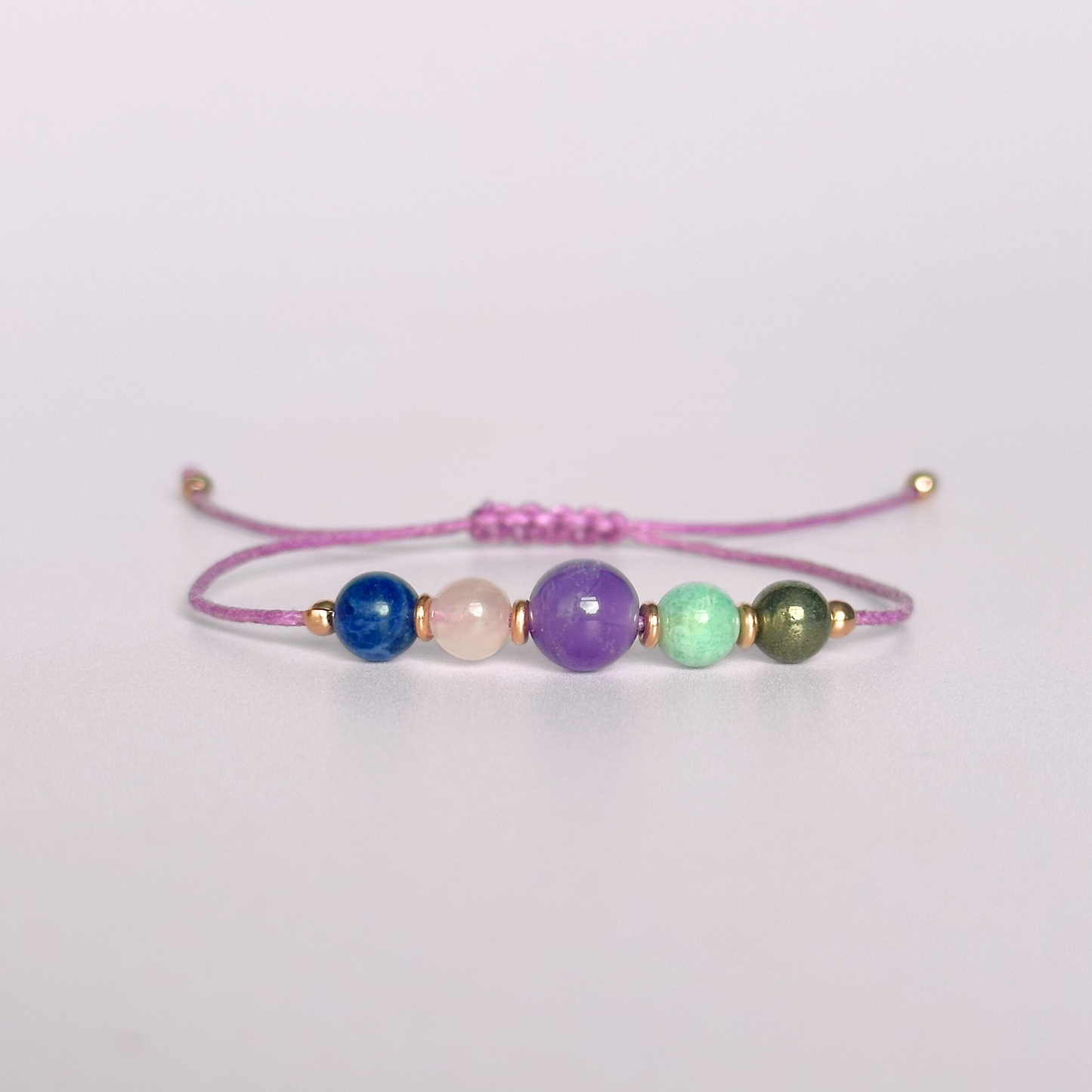 Eco-friendly, waxed cotton cord crystal healing bracelet featuring five crystals each believed to help deal with anxiety. Includes pyrite, amazonite, amethyst, rose quartz and sodalite. Adjustable as it fastens with a sliding macramé clasp. Choose from either sterling silver, gold vermeil or rose gold vermeil accent beads.