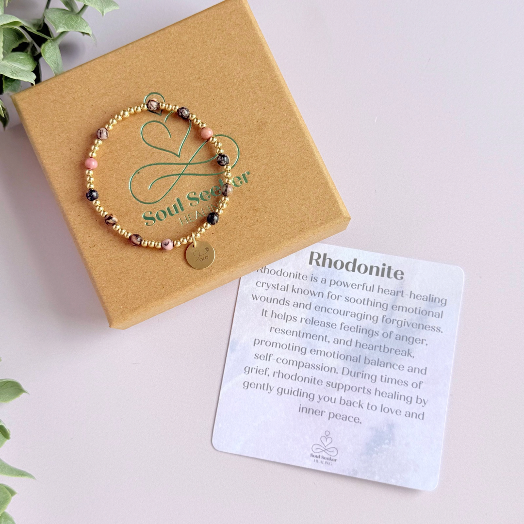 Gold filled bracelet featuring ethically mined 4mm rhodonite crystal beads, separated by 3mm gold filled beads. It features an 11mm gold filled disc charm, which is engraved with a love heart and paw design, which can be personalised with your pet's name. The reverse of the charm says 'Forever in your heart x', although this side can also be personalised with your own words.