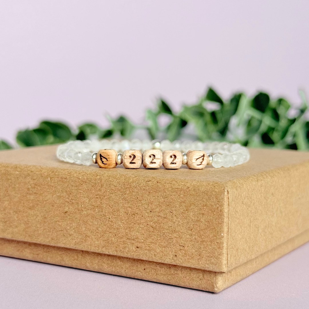 Bracelet featuring engraved wooden 222 angel number and wing beads, on the band of 4mm faceted moonstone round crystal gemstone beads. Finished with your choice of gold vermeil, sterling silver or rose gold vermeil accent beads.