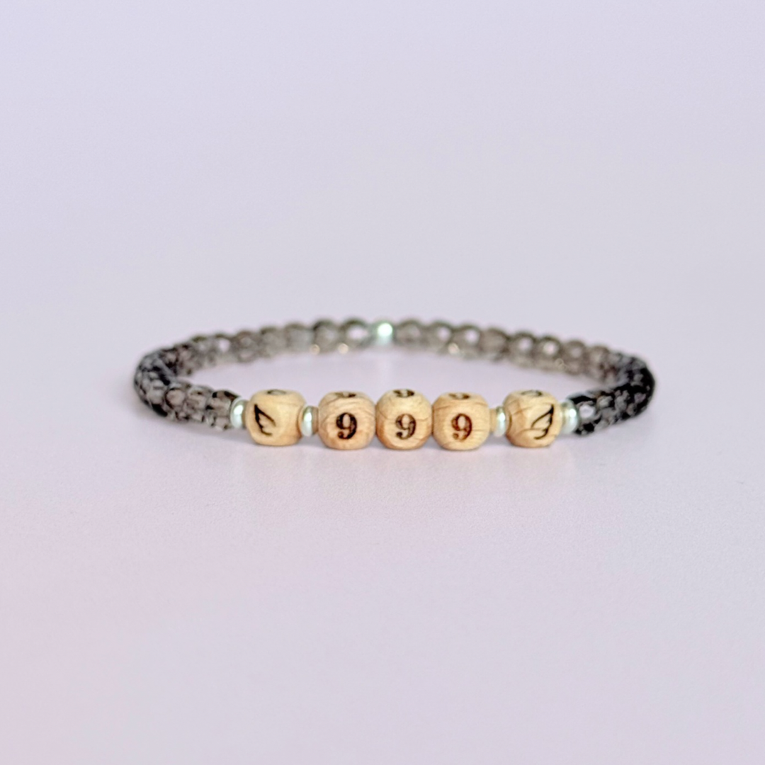 Bracelet featuring engraved wooden 999 angel number and wing beads, on the band of 4mm faceted smoky quartz round crystal gemstone beads. Finished with your choice of gold vermeil, sterling silver or rose gold vermeil accent beads.