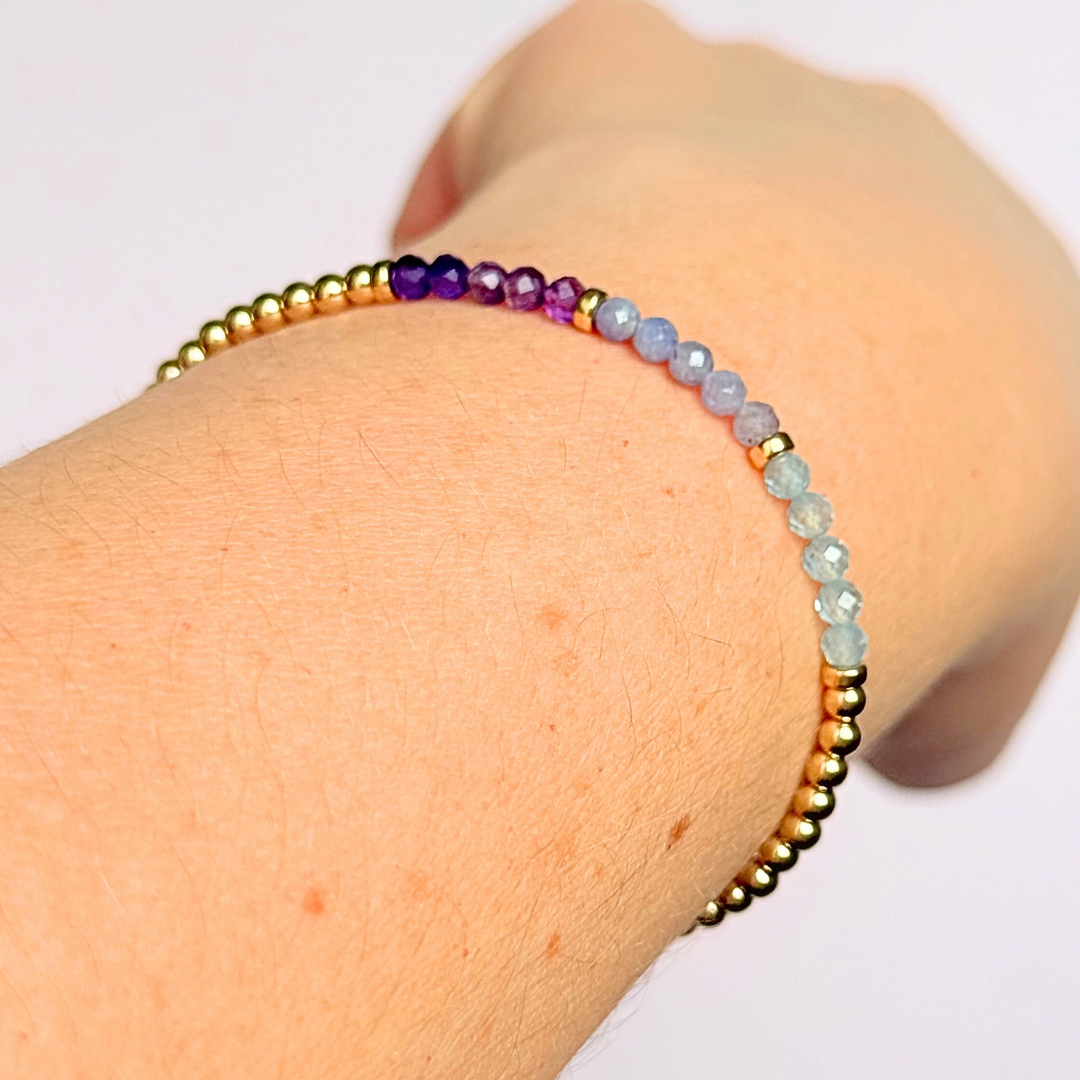 Dainty minimalist yellow gold filled crystal bracelet featuring 3mm faceted amethyst, aquamarine and tanzanite beads in a colour block Ombre style. Fastens with a gold filled lobster clasp with an extender chain.