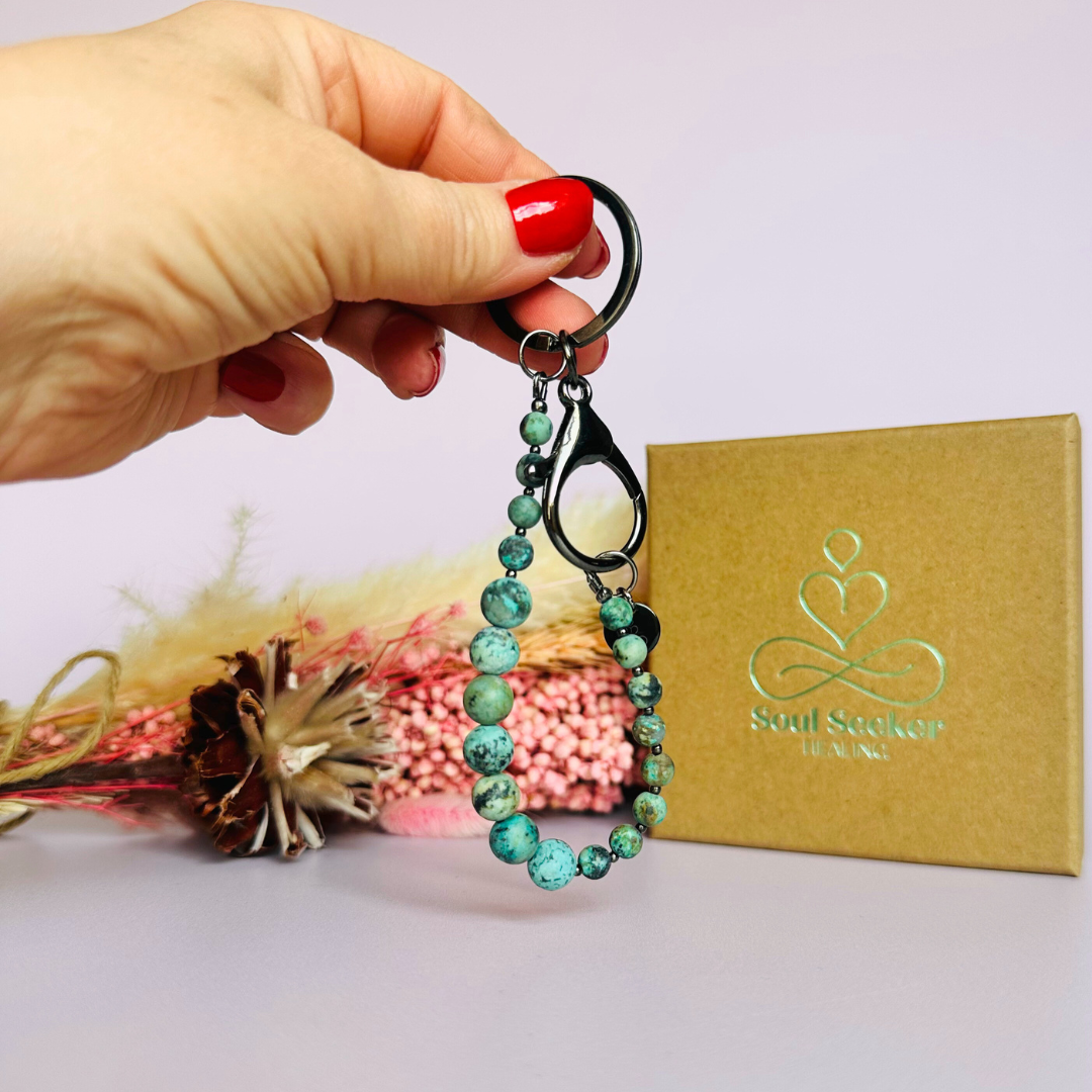 Frosted African turquoise breath work beads on a black plated keychain/bag charm. For the 4-7-8 counted breathing method.