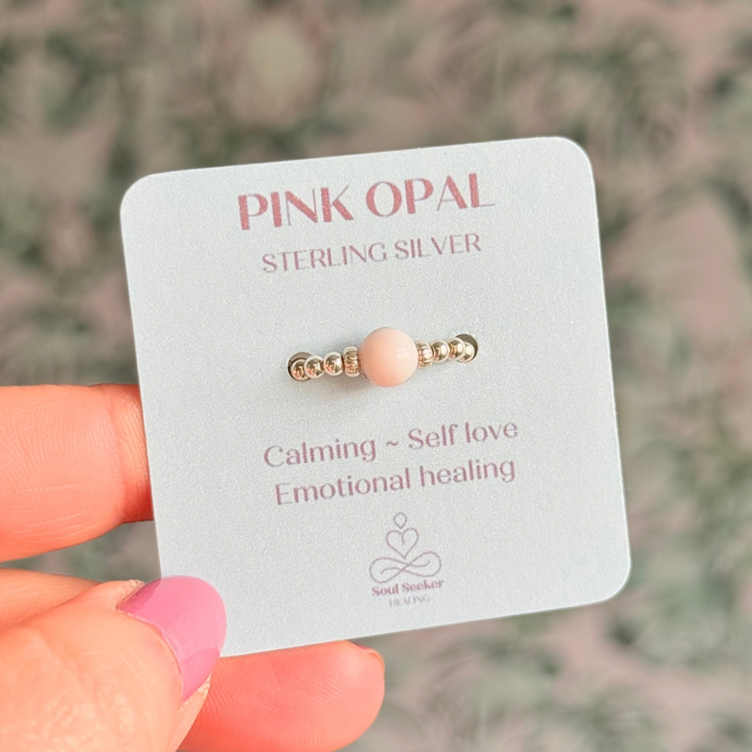 Sterling silver pink opal October birthstone ring featuring a 6mm smooth, round pink opal bead on a band of 2.5mm sterling silver ball beads. Elasticated for comfort.