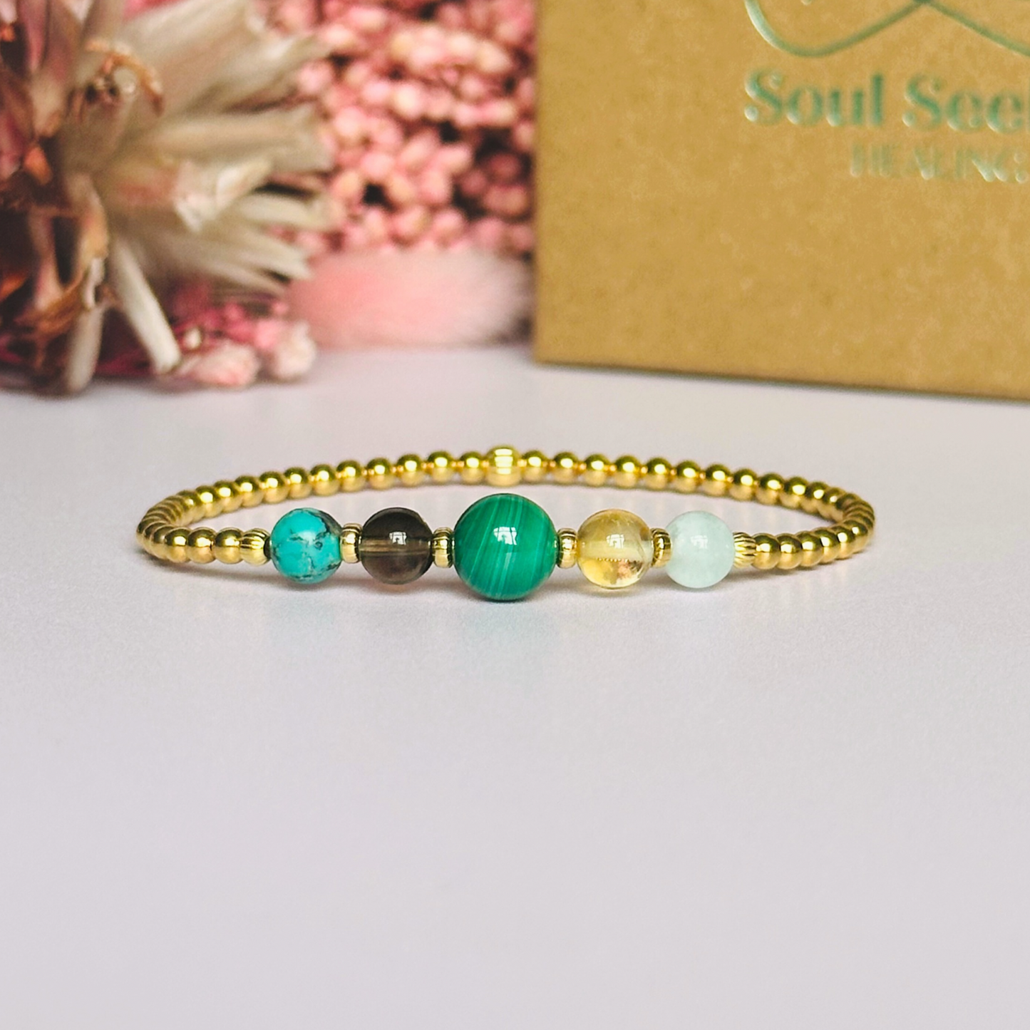 This gold vermeil Scorpio bracelet is made with a selection of five healing crystals all believed to resonate with the Scorpio zodiac sign. The central bead is 8mm, the other four are 6mm. On an elasticated band of 3mm gold vermeil beads with corrugated accent beads. Featuring aquamarine, citrine, malachite, smoky quartz and turquoise.