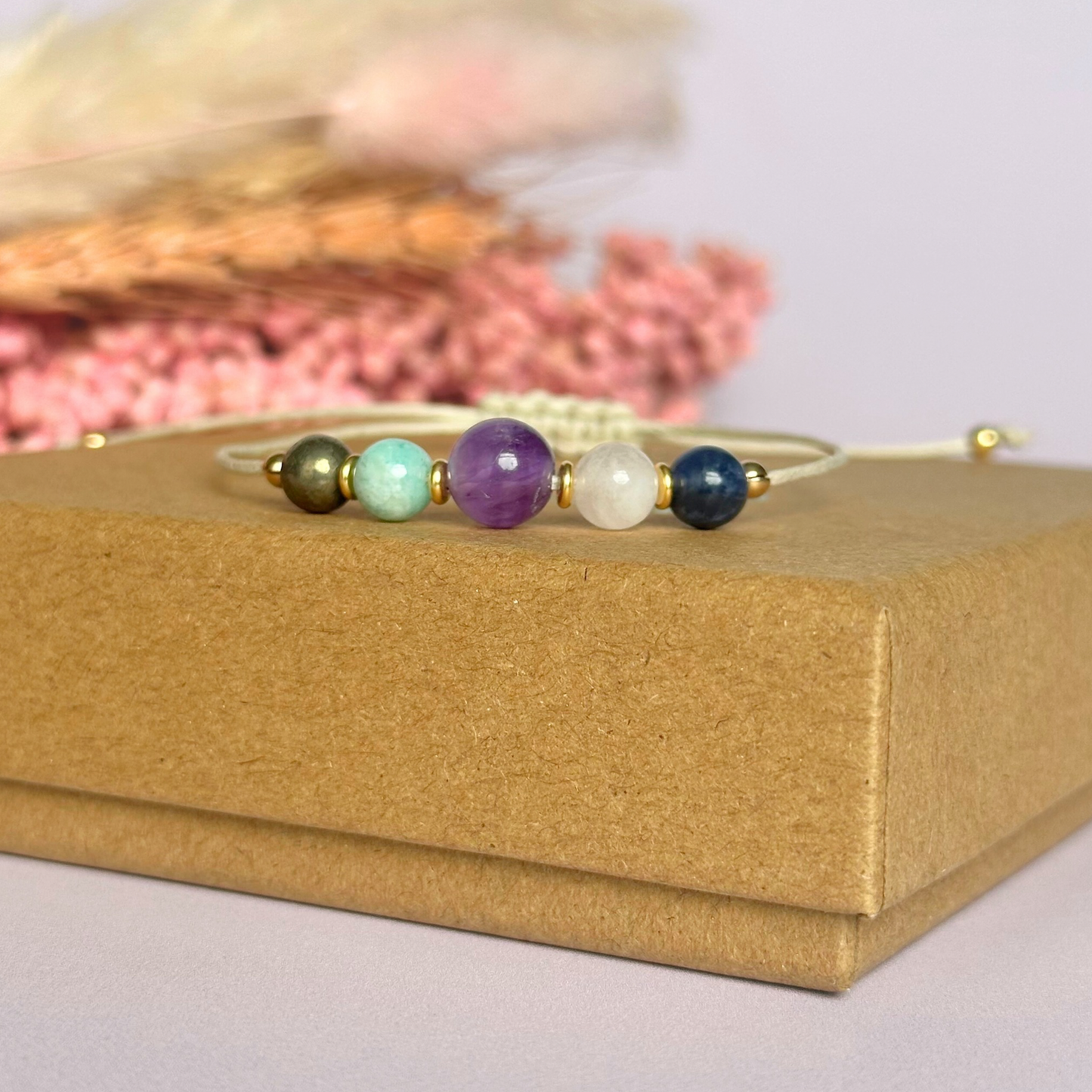 Eco-friendly, waxed cotton cord crystal healing bracelet featuring five crystals each believed to help deal with anxiety. Includes pyrite, amazonite, amethyst, rose quartz and sodalite. Adjustable as it fastens with a sliding macramé clasp. Choose from either sterling silver, gold vermeil or rose gold vermeil accent beads.
