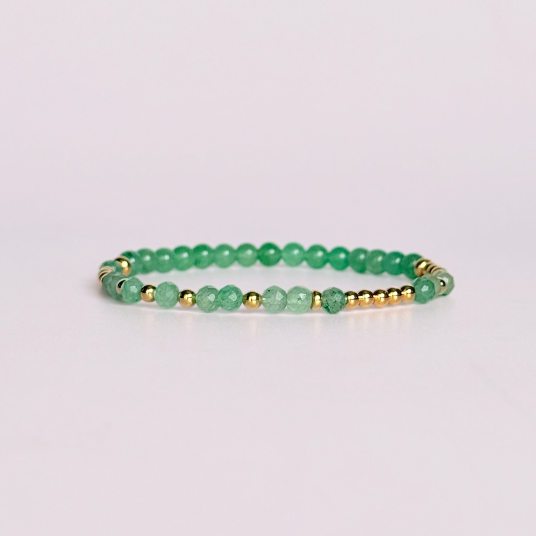 Elasticated green aventurine crystal morse code bracelet spells out the words ‘Lucky bitch’ in a combination of 4mm round green aventurine beads, 4mm faceted green aventurine beads and either sterling silver or gold vermeil 3mm round beads. The words start and end at the rondelle spacer beads.