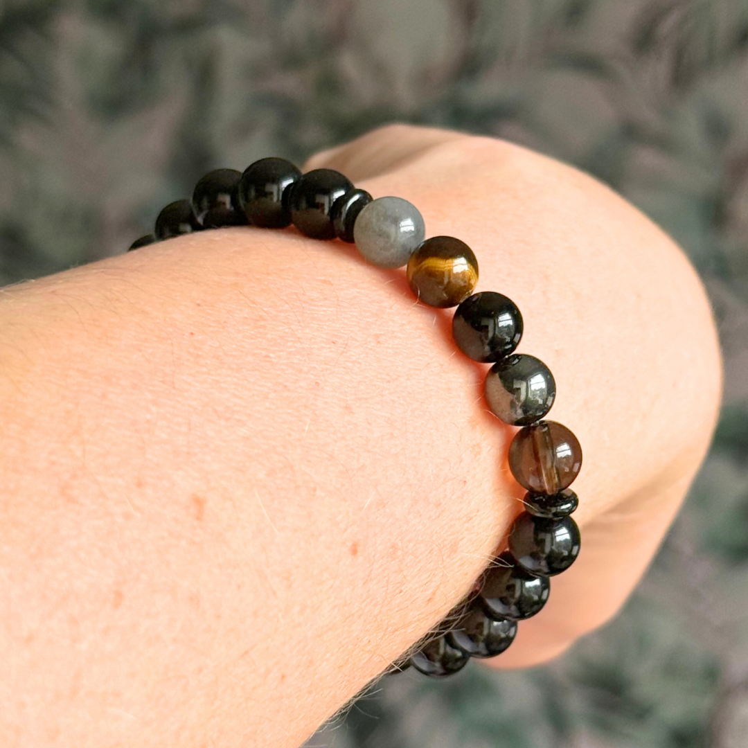 Men’s grief support bracelet featuring 8mm crystal beads which are believed to help with the various aspects of grief and loss. Includes black obsidian, black onyx, labradorite, tigers eye, hematite and smoky quartz.