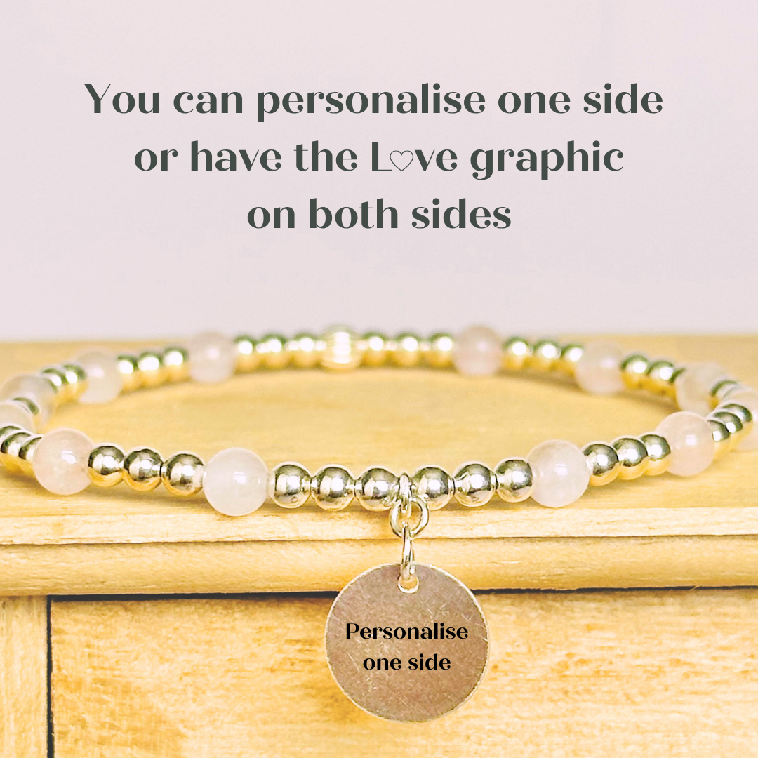 Sterling silver elasticated bracelet featuring 4mm round rose quartz beads, separated by 3mm sterling silver round ball beads. Featuring an 11mm sterling silver round disc charm engraved with the words love. One side of the charm can be personalised if required.