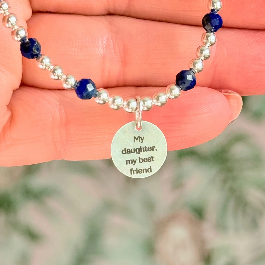 Sterling silver bracelet features 4mm lapis lazuli faceted beads, separated by 3mm sterling silver round beads. Lapis lazuli is a September birthstone. The focal point is an 11mm sterling silver charm, engraved with a large and smaller heart design. This charm can be personalised on one side if required or feature the same graphic on both sides.