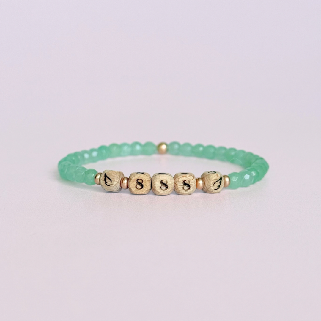 Bracelet featuring engraved wooden 888 angel number and wing beads, on the band of 4mm faceted green aventurine round crystal gemstone beads. Finished with your choice of gold vermeil, sterling silver or rose gold vermeil accent beads.