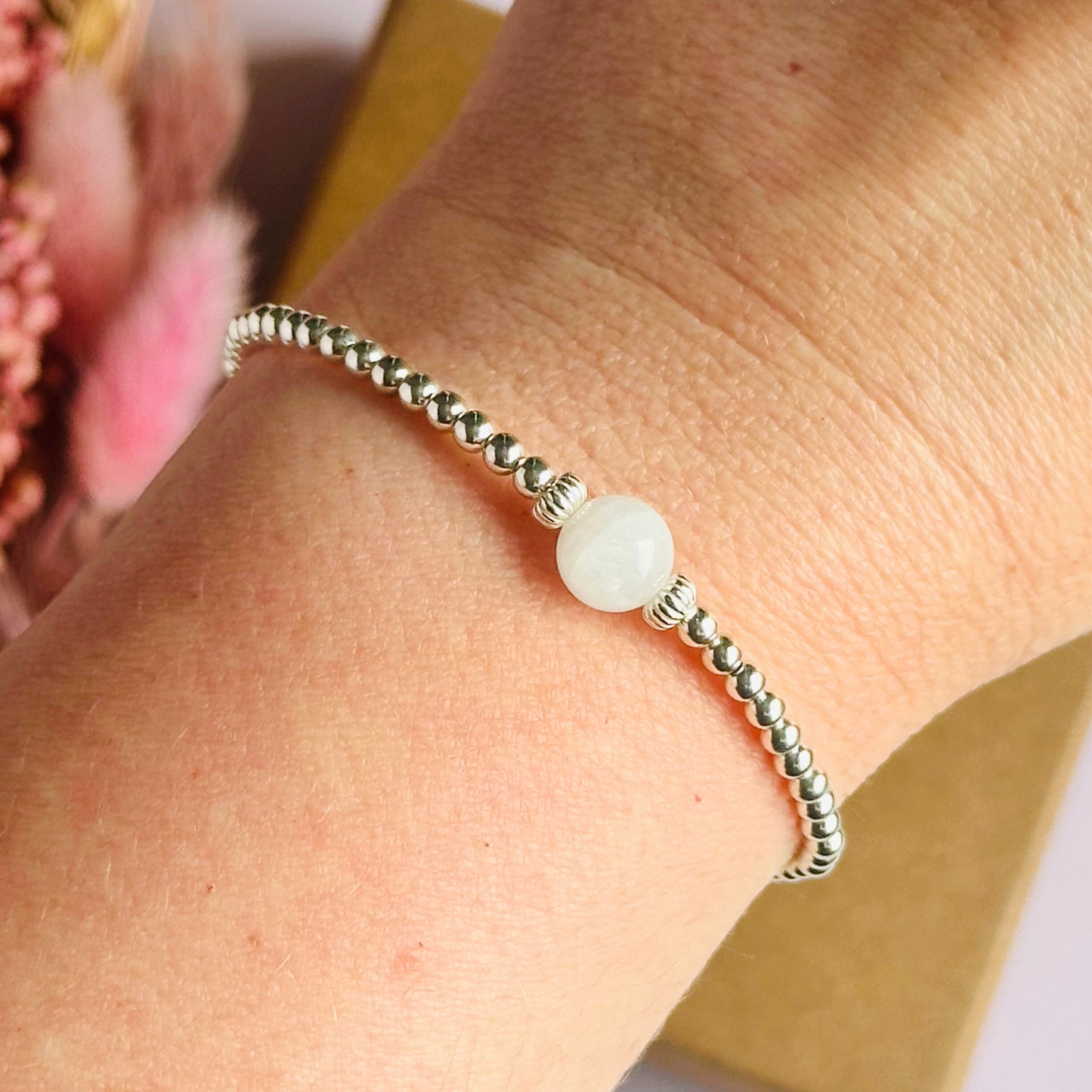Sterling silver moonstone bracelet features an ethically mined 8mm moonstone bead, flanked by corrugated rondelle beads on a band of 3mm sterling silver beads. A bracelet to promote feminine energy and intuition.