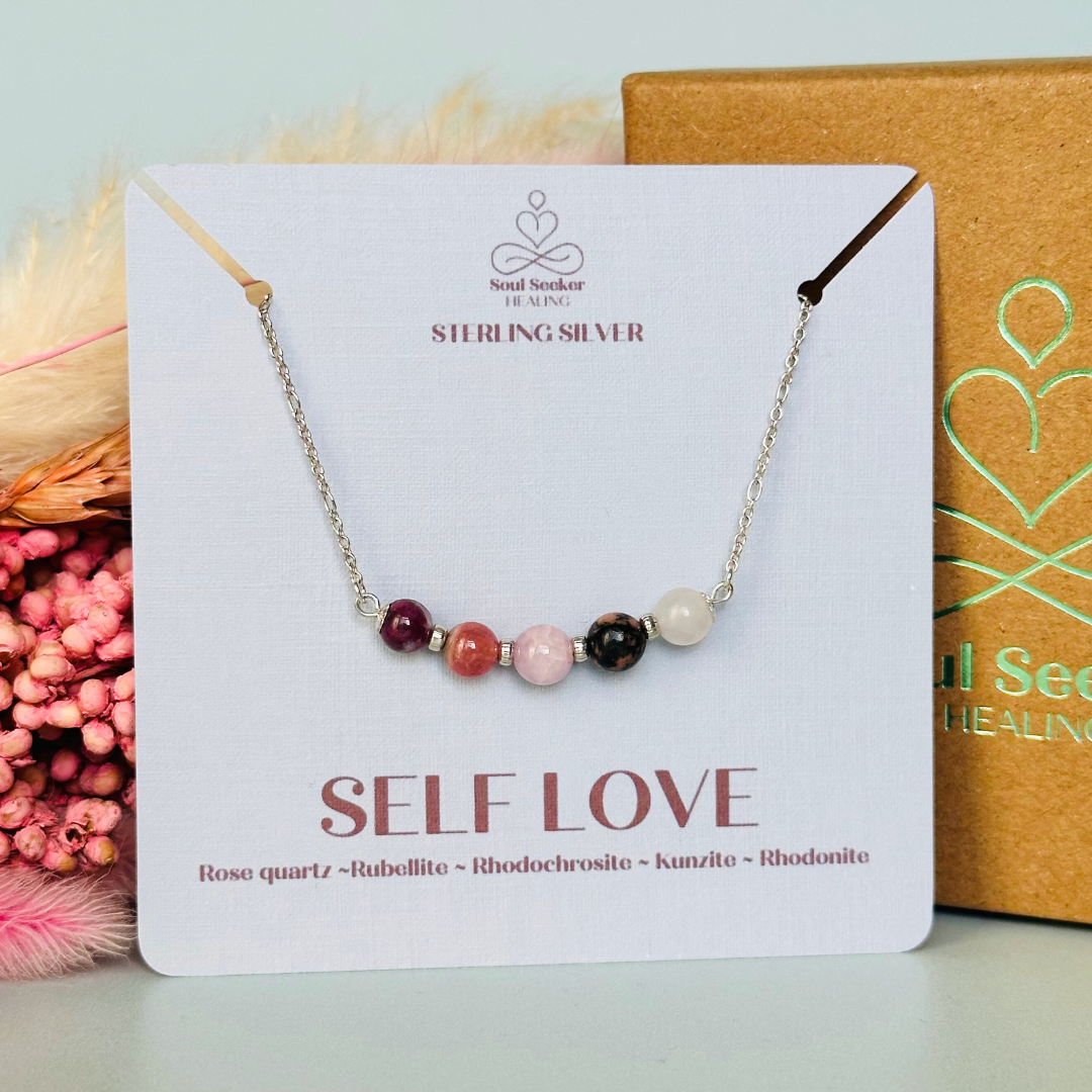 A dainty self love crystal necklace made with a selection of five healing crystals all believed to help promote self love. On a fine, sterling silver figaro chain, which fastens with a sterling silver bolt clasp. Featuring corrugated sterling silver spacer beads and accented with daisy shaped bead caps.