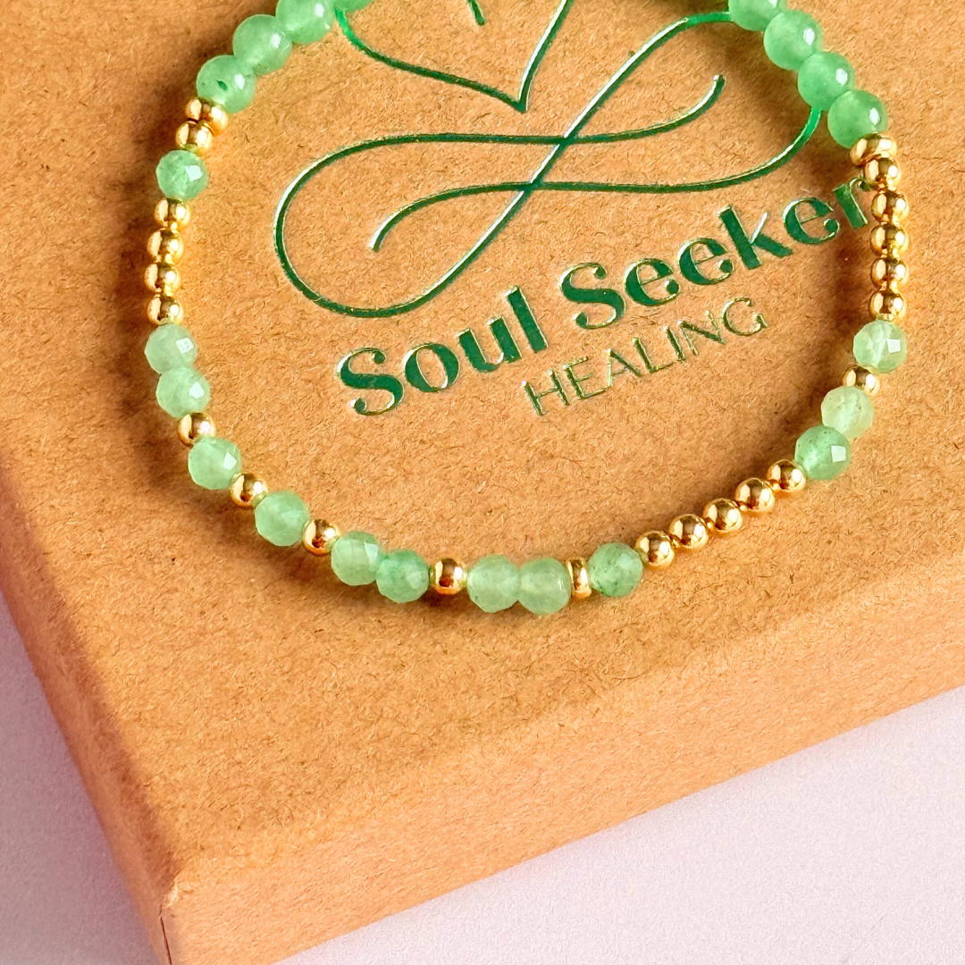 Elasticated green aventurine crystal morse code bracelet spells out the words ‘Lucky bitch’ in a combination of 4mm round green aventurine beads, 4mm faceted green aventurine beads and either sterling silver or gold vermeil 3mm round beads. The words start and end at the rondelle spacer beads.
