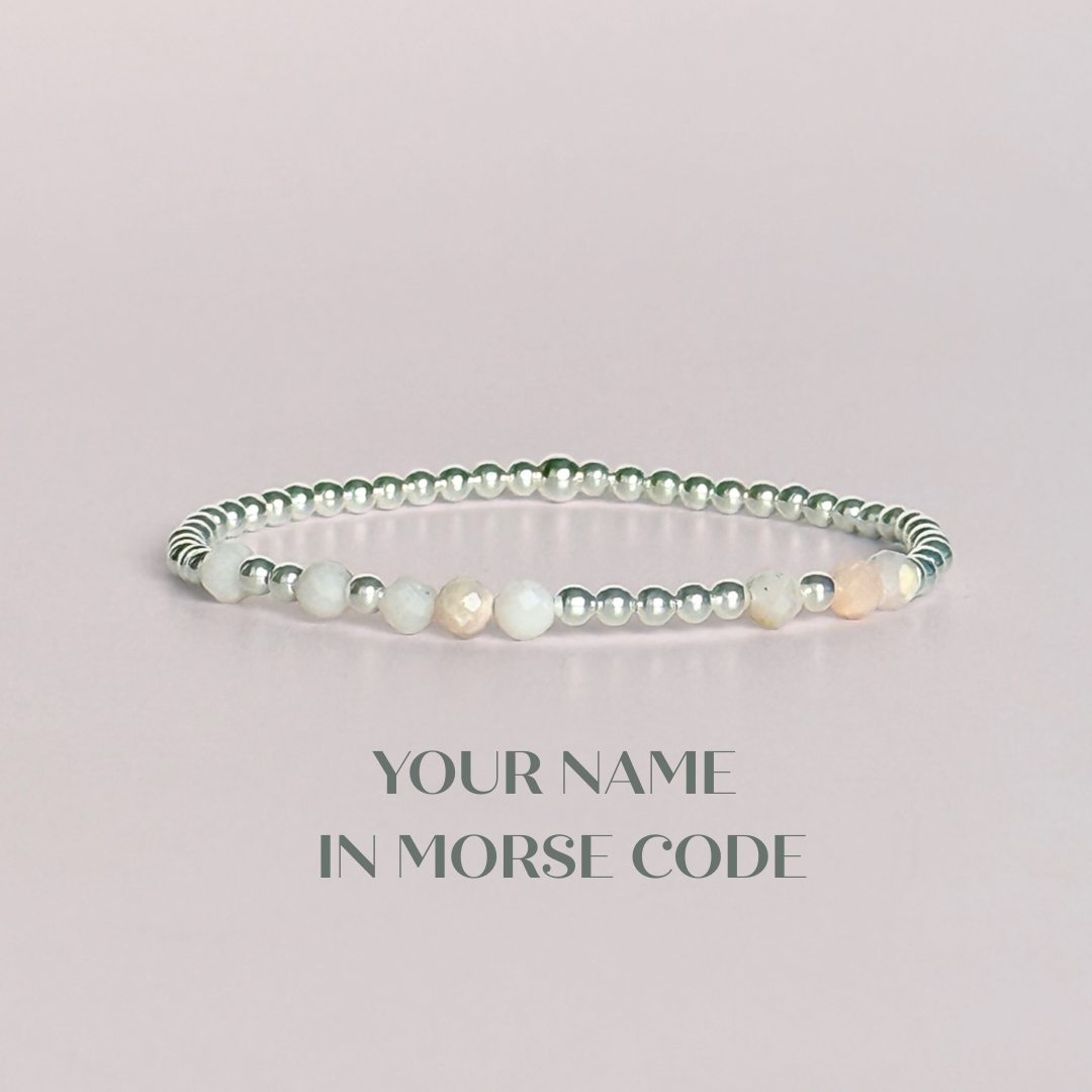 Morse code secret message bracelet spelling out your chosen name in sterling silver and pink opal crystal beads. Elasticated with 4mm faceted pink opal beads and 3mm sterling silver beads. Custom October birthstone bracelet.
