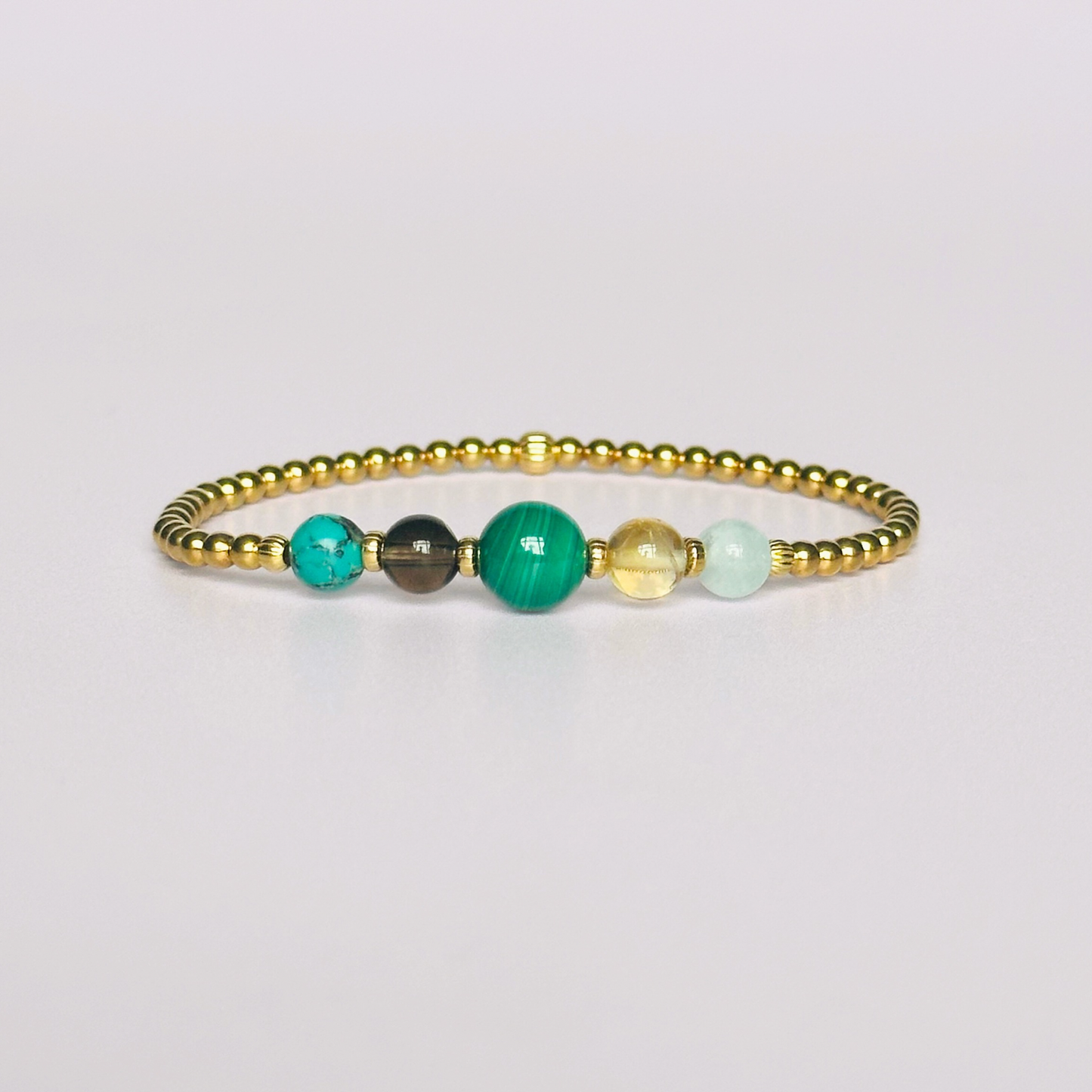 This gold vermeil Scorpio bracelet is made with a selection of five healing crystals all believed to resonate with the Scorpio zodiac sign. The central bead is 8mm, the other four are 6mm. On an elasticated band of 3mm gold vermeil beads with corrugated accent beads. Featuring aquamarine, citrine, malachite, smoky quartz and turquoise.