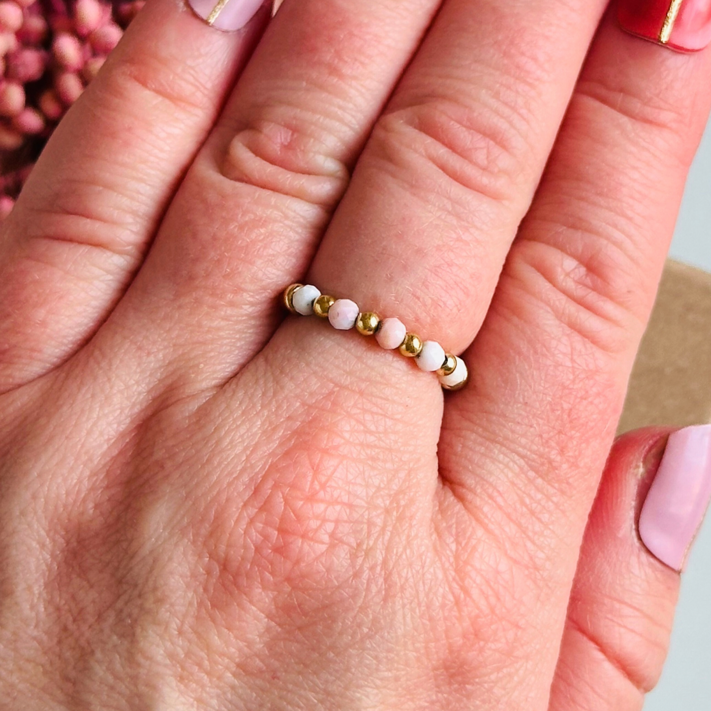 Birthstone ring featuring 5 3mm. Faceted Peruvian pink opal beads on an elasticated band of 3mm gold vermeil round beads, pink opal is an October birth stone so this makes a perfect October birthday gift.