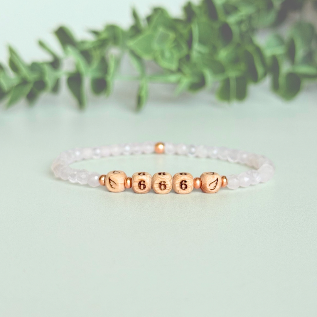 Bracelet featuring engraved wooden 666 angel number and wing beads, on the band of 4mm faceted rose quartz round crystal gemstone beads. Finished with your choice of gold vermeil, sterling silver or rose gold vermeil accent beads.