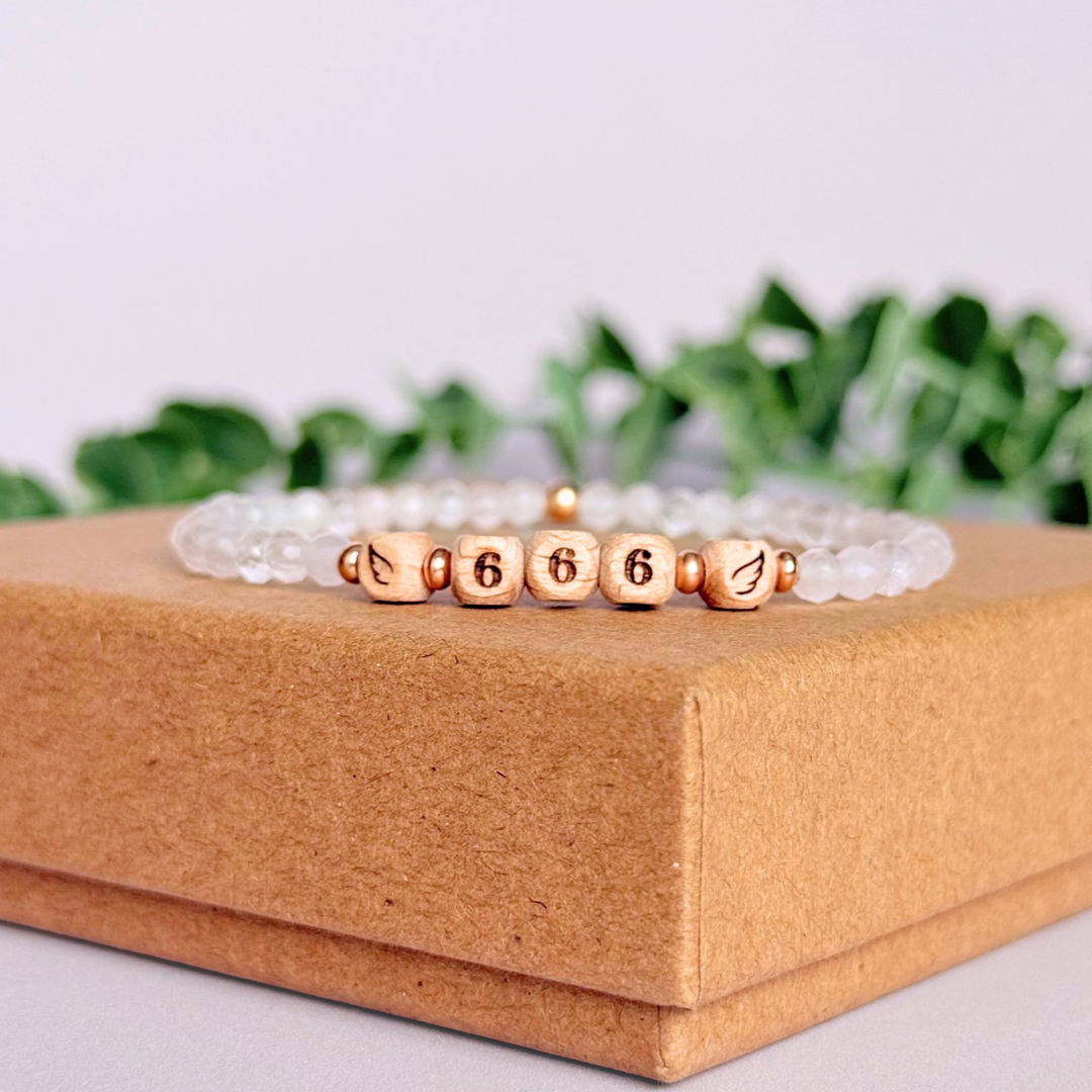 Bracelet featuring engraved wooden 666 angel number and wing beads, on the band of 4mm faceted rose quartz round crystal gemstone beads. Finished with your choice of gold vermeil, sterling silver or rose gold vermeil accent beads.