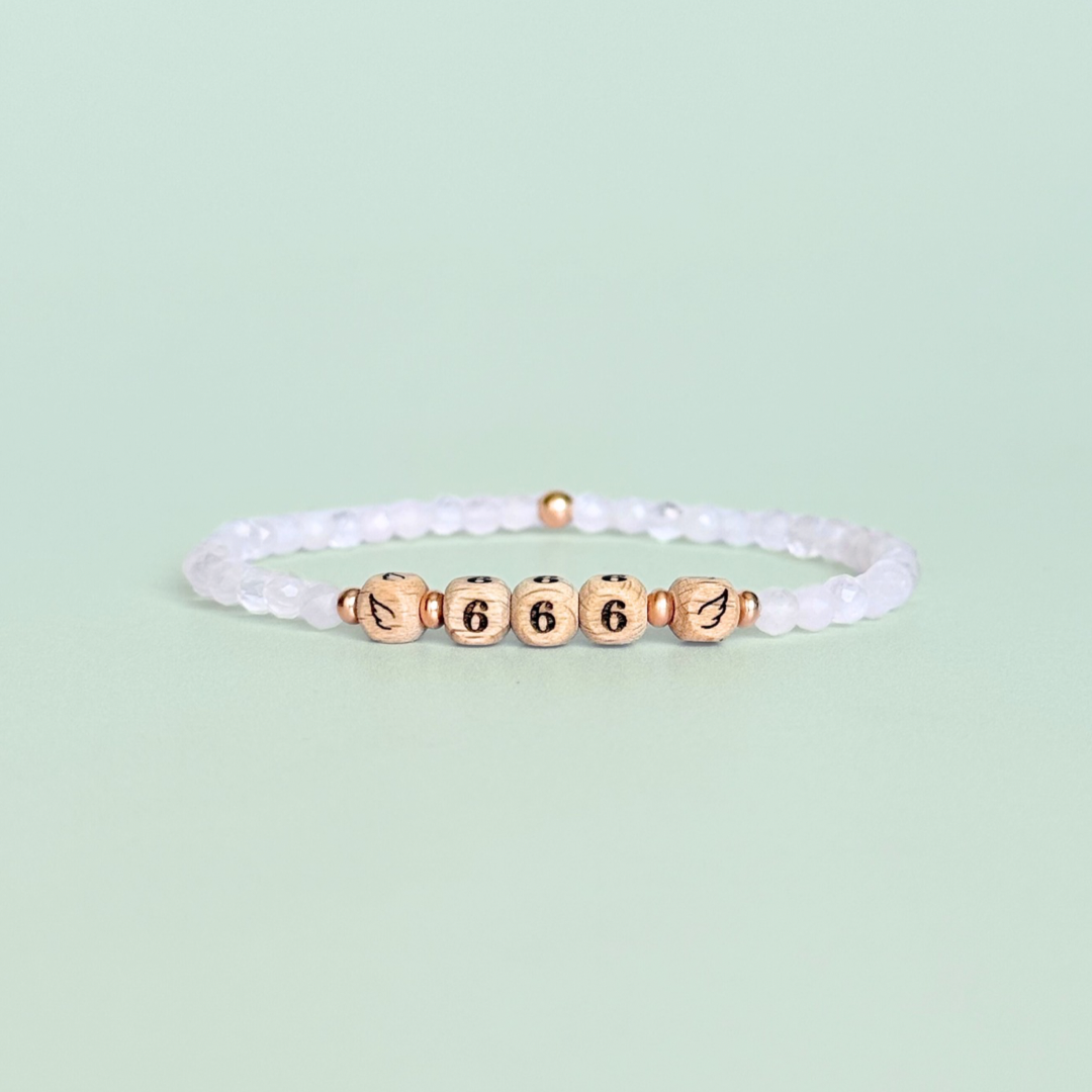 Bracelet featuring engraved wooden 666 angel number and wing beads, on the band of 4mm faceted rose quartz round crystal gemstone beads. Finished with your choice of gold vermeil, sterling silver or rose gold vermeil accent beads.