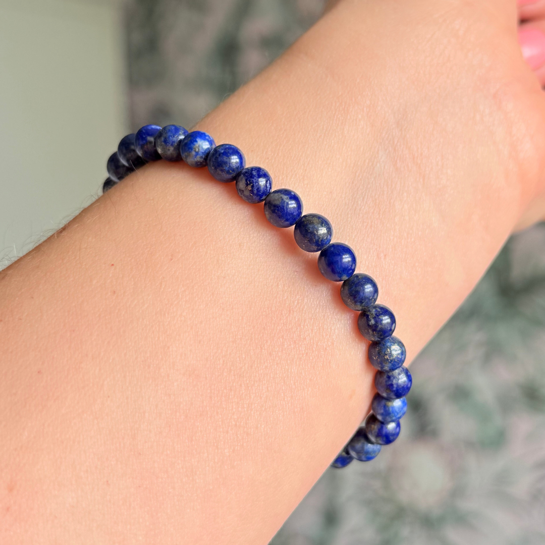 Genuine lapis lazuli bracelet featuring 6mm, smooth, round dark blue lapis lazuli beads and your choice of a 6mm faceted gold vermeil or sterling silver accent bead. Elasticated for comfort.