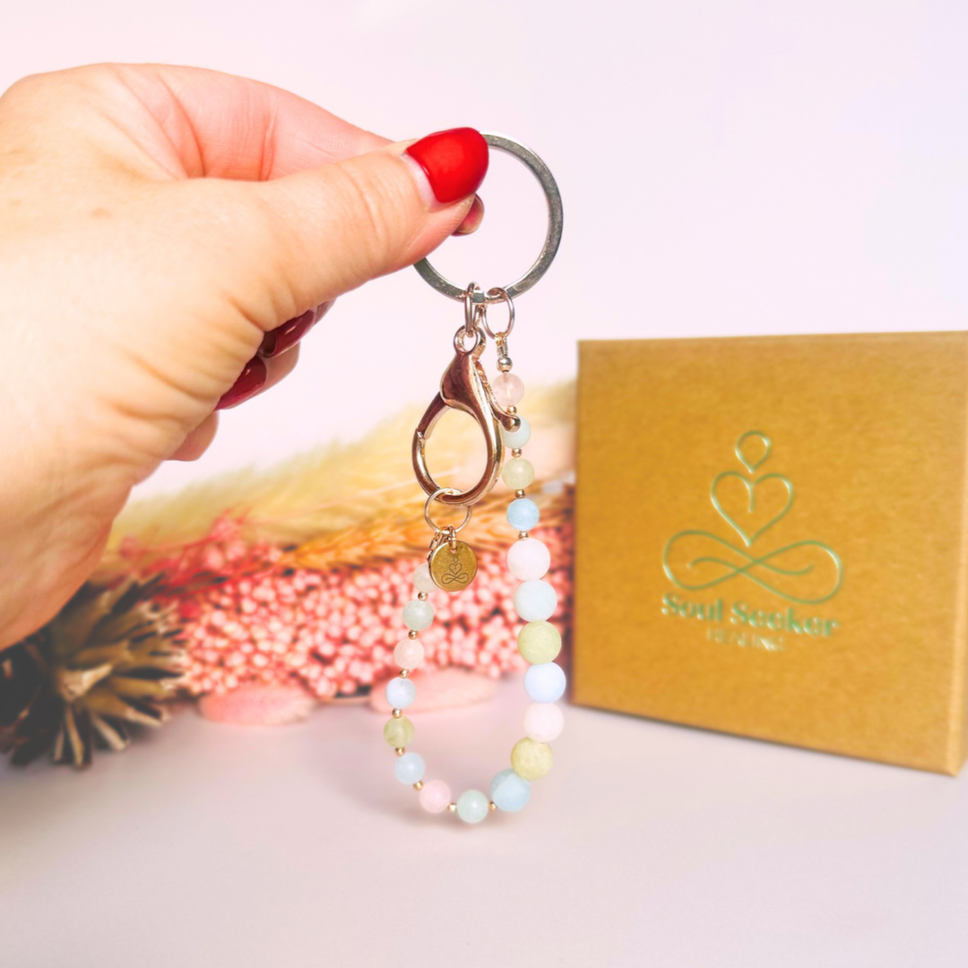 Frosted morganite breath work beads on a rose gold keychain/bag charm. For the 4-7-8 counted breathing method.