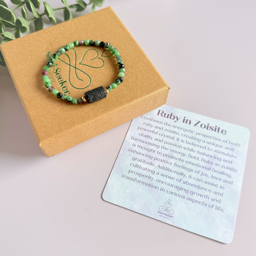 Essential oil diffuser bracelet featuring black lava rock tube bead on the band of 4mm faceted ruby in zoisite beads. Finished with your choice of sterling silver or gold vermeil accent beads.