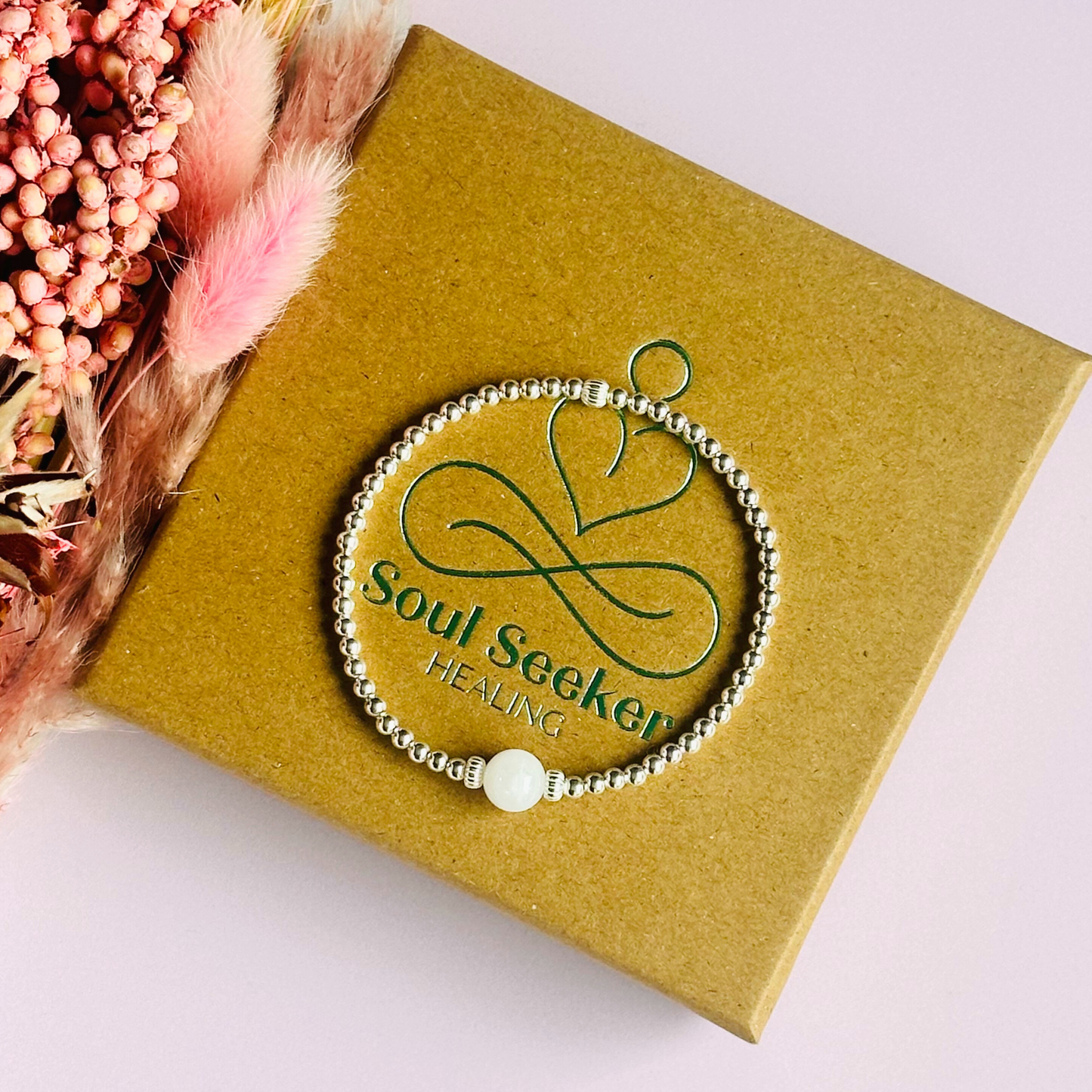 Sterling silver moonstone bracelet features an ethically mined 8mm moonstone bead, flanked by corrugated rondelle beads on a band of 3mm sterling silver beads. A bracelet to promote feminine energy and intuition.