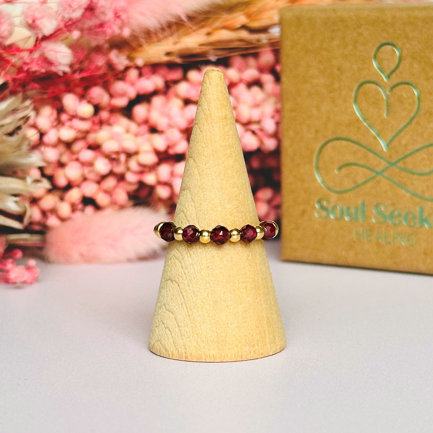 Gold vermeil garnet ring featuring five 3mm faceted round garnet beads on a elasticated ring band of 2.5mm gold vermeil beads.