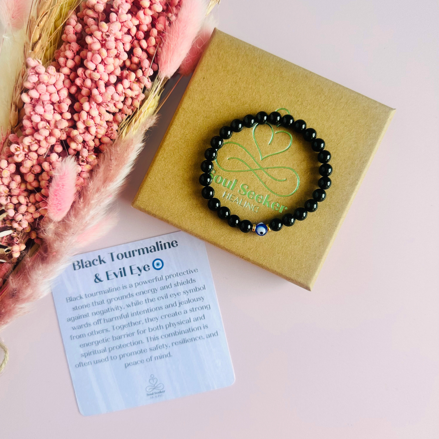 Natural black tourmaline bracelet featuring ethically mined smooth 6mm round beads with a beautiful blue Turkish evil eye glass bead as the focal point. Finished with gold vermeil or sterling silver accent beads.