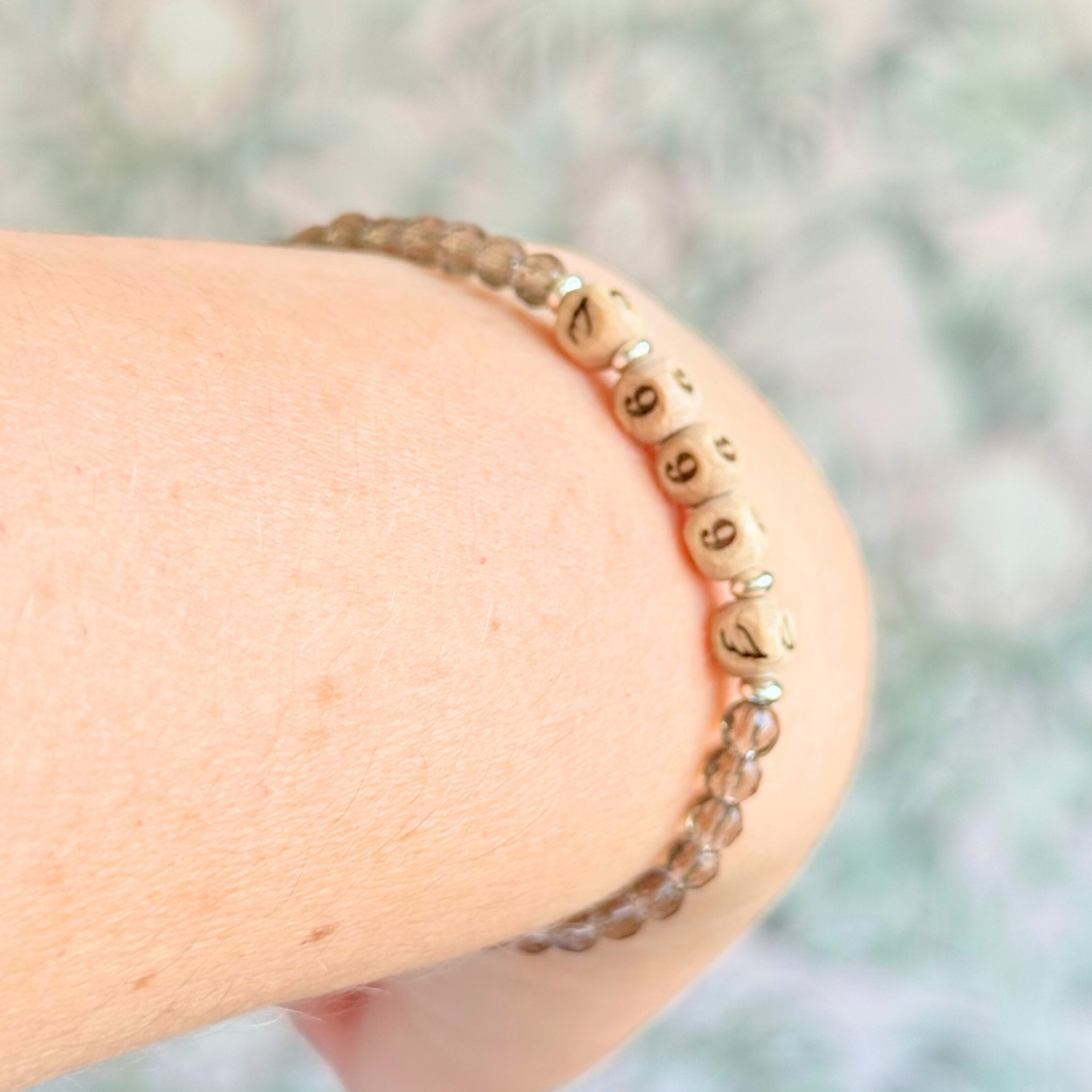 Bracelet featuring engraved wooden 999 angel number and wing beads, on the band of 4mm faceted smoky quartz round crystal gemstone beads. Finished with your choice of gold vermeil, sterling silver or rose gold vermeil accent beads.
