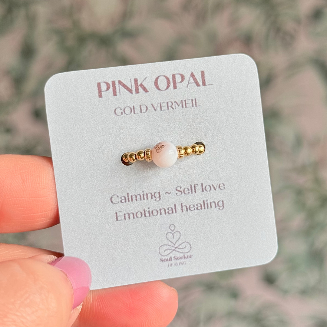 Gold vermeil pink opal October birthstone ring featuring a 6mm smooth, round pink opal bead on a band of 2.5mm gold vermeil ball beads. Elasticated for comfort.